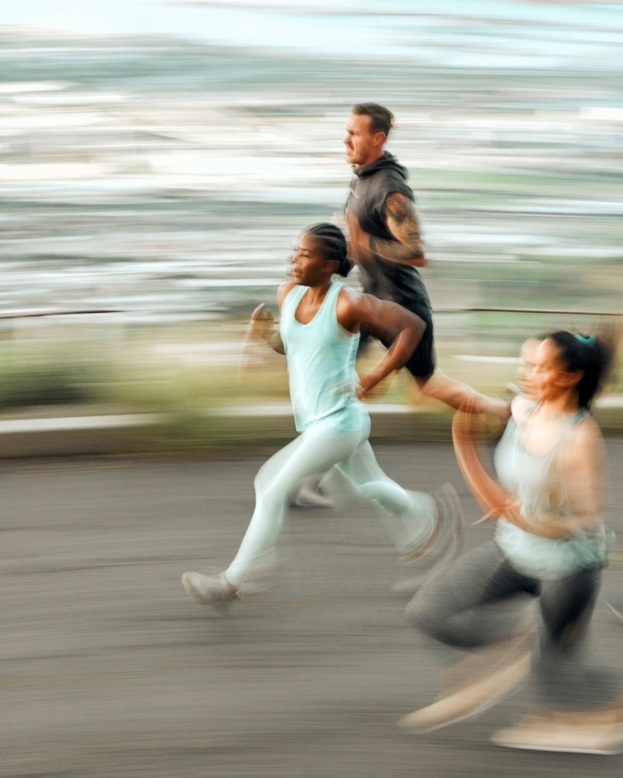 Four runners in a race on a blurred road background