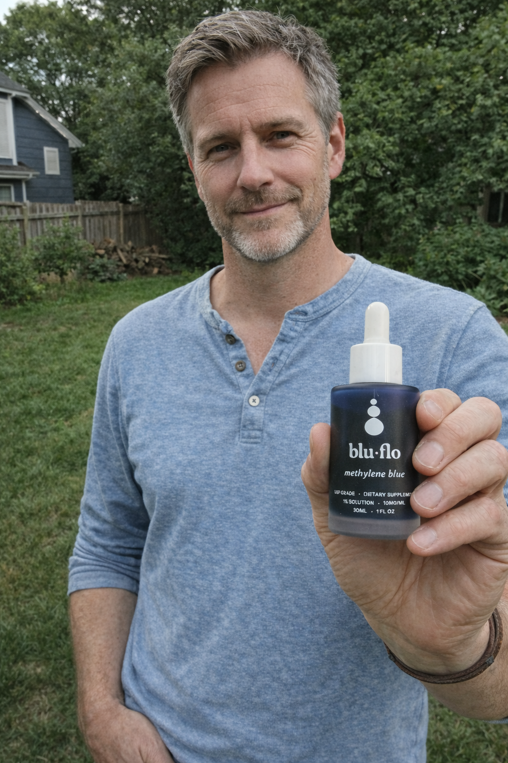 Man holding a blu-flo methylene blue bottle outdoors